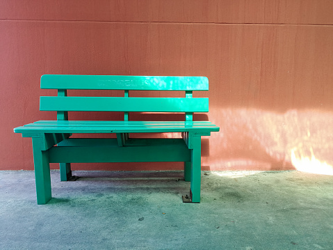 An old faded wooden park bench in the sun.