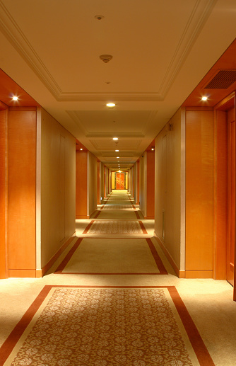 Empty hotel corridor with maid cart for room service.