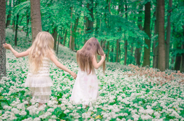 beautiful girls with long hair in spring forest back view
