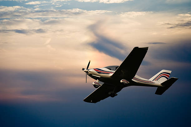 Air to air photo of a modern civil cirrus airplane with propeller flying over the agricultural fields, landing gears down.