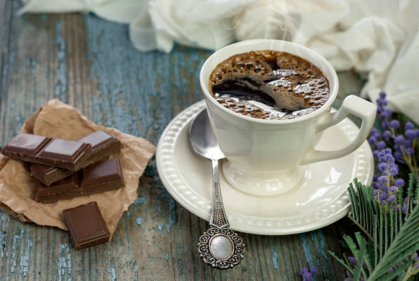 istock Coffee cup and chocolate on wooden table texture. 931445800
