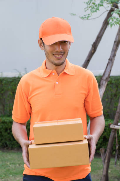 istock Delivery man in orange bringing package to your home 931446058