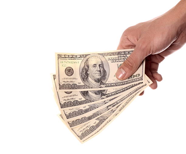 Hand holding $600 over white background isolated. stock photo