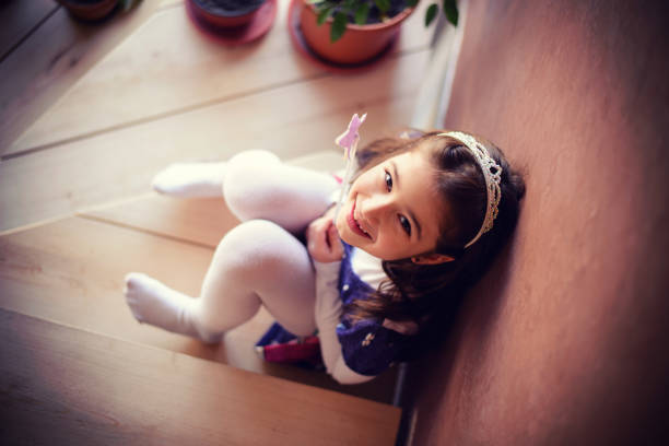 cute princess standing on the stairway with a bright slightly shy smile. fairy tale portrait. series.