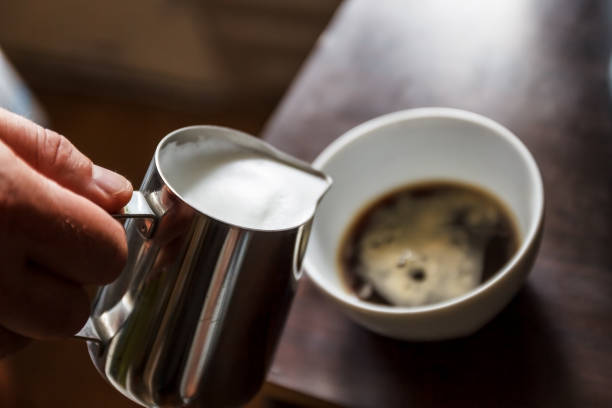 istock man pouring into a cup of coffee with milk 931448986
