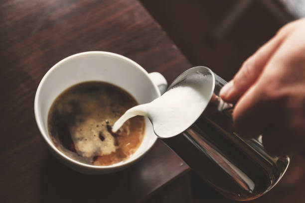 istock man pouring into a cup of coffee with milk 931448998
