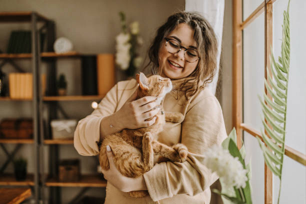 unbeschwerte frau mit katze - cat woman stock-fotos und bilder