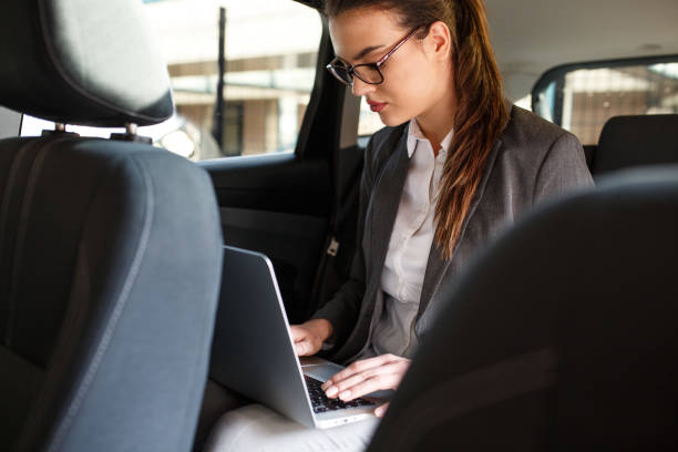 istock Attractive businesswoman using laptop in the car. 931453670