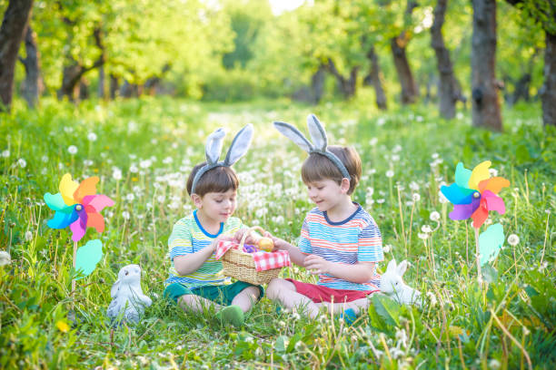 イースターのための着色された卵を楽しんで、公園で二人の少年 - poultry baby chicken eggs chicken ストックフォトと画像