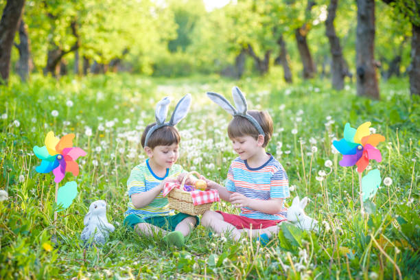 dois meninos no parque, divertindo-se com ovos coloridos para páscoa - chicken baby chicken animal egg animal - fotografias e filmes do acervo