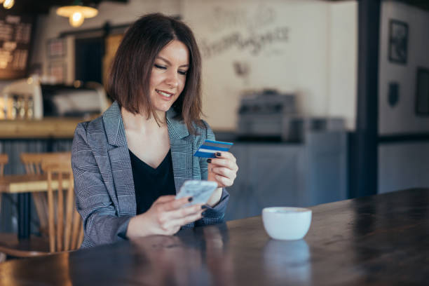 istock Woman in cafe using credit card for online payments 931461222