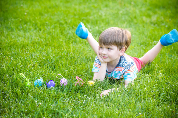 istock Little boy hunting for easter egg in spring garden on Easter day. Cute little child with traditional bunny celebrating feast 931461926