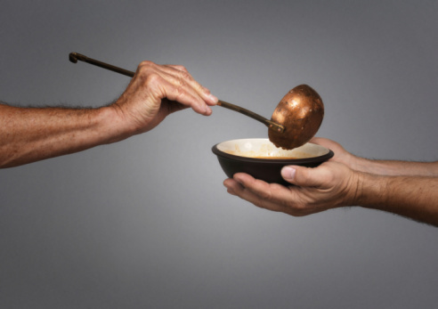 Eating pumpkin seeds, hand taking pumpkin seeds from a bowl on the white background with copy space