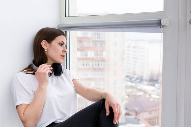 istock Beautiful happy woman sitting by the window 931464842