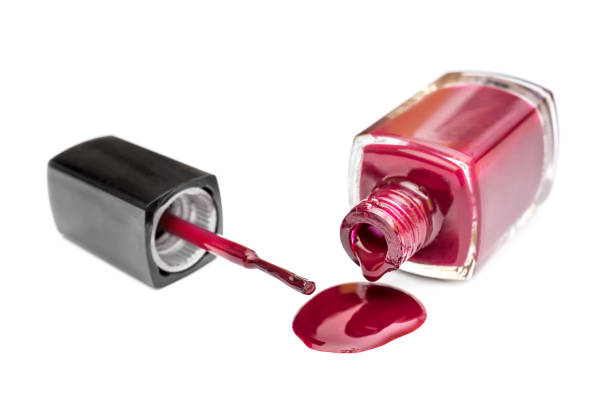 istock Red nail polish spilled from the bottle with brush on white background. 931465966