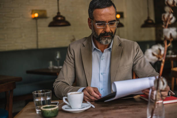 istock Senior businessman in an internet cafe working 931469674