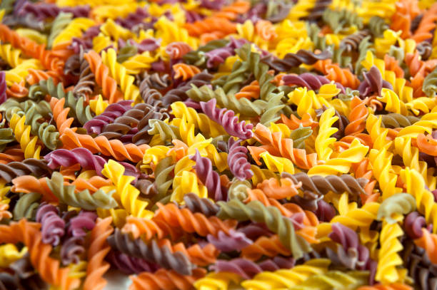 istock Food background - uncooked three-colored Fusilli durum wheat pasta with spinach and tomato 931470208