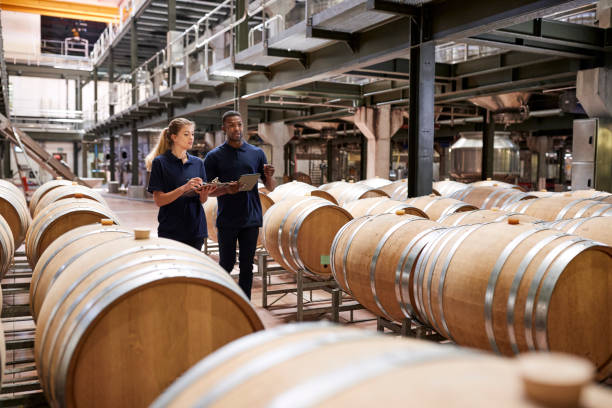 istock Two staff inspecting barrels in a wine factory warehouse 931470416