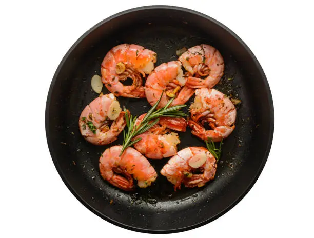 Pan of grilled prawn shrimps with garlic rosemary and spices isolated on white background, top view