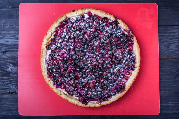 istock Delicious mascarpone cheesecake with currant on wooden table background, top view. 931473192
