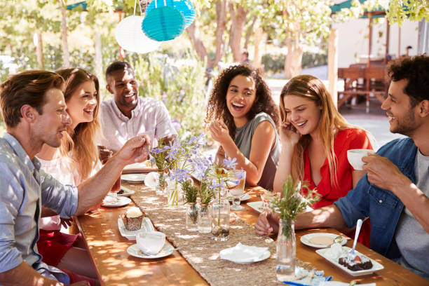 istock Six young friends dining at a table outdoors 931473432