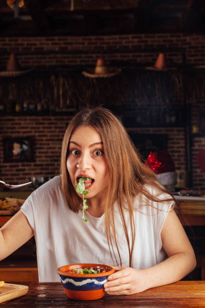 istock Young woman eating salad 931476008