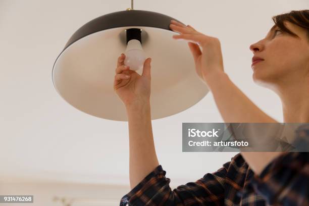 Woman Replacing Light Bulb At Home Power Save Led Lamp Changing Stock Photo - Download Image Now