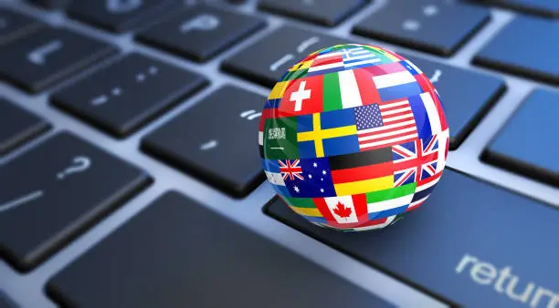 International business concept with a computer keyboard and world flags on a globe 3D illustration.