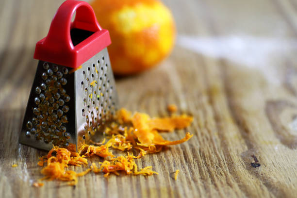 терка цедры цитрусовых и на деревянном столе - grater grated peel ingredient стоковые фото и изображения