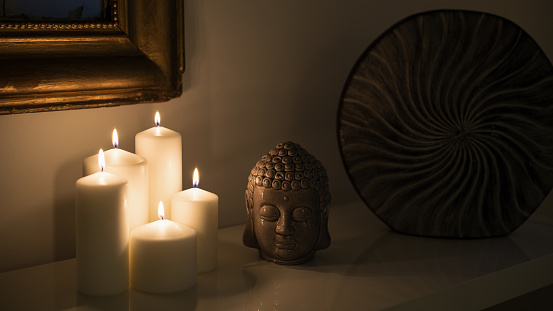Budda figurine  and Candles Burning at Night