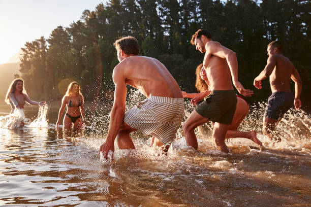 istock Young adult group on vacation having fun in a lake 931480582