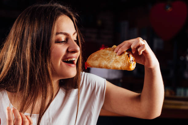 istock Young woman eating taco 931483482