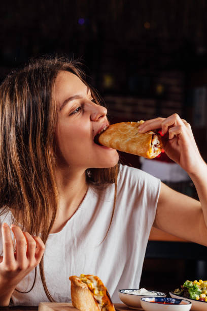 Young woman eating taco
