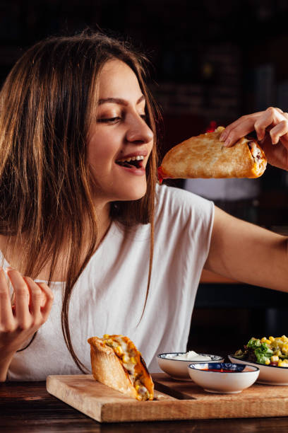 istock Young woman eating taco 931483932