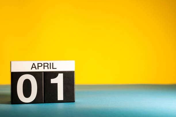 le 1er avril. jour 1 du mois d’avril, calendar sur table avec fond jaune. temps de printemps, un espace vide pour texte - poisson davril photos et images de collection