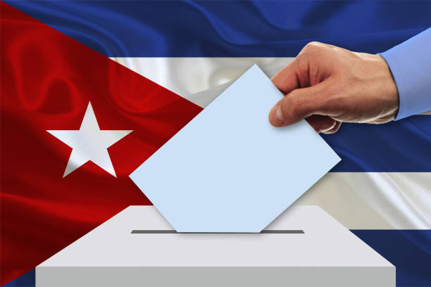 istock Man voting on elections in Cuba front of flag 931487328
