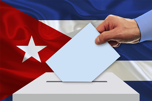 Man voting on elections in Cuba front of flag