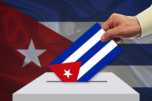 Man voting on elections in Cuba front of flag