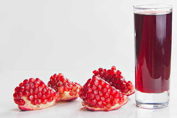 delicious juice from ripe pomegranate in beautiful glass on a white table
