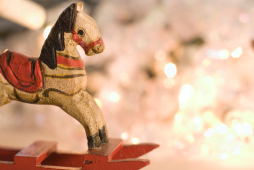 A vintage wood rocking horse with Christmas lights in the background. Photo taken with a manual macro lens.