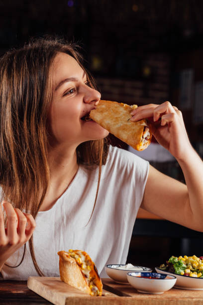 istock Young woman eating taco 931490906