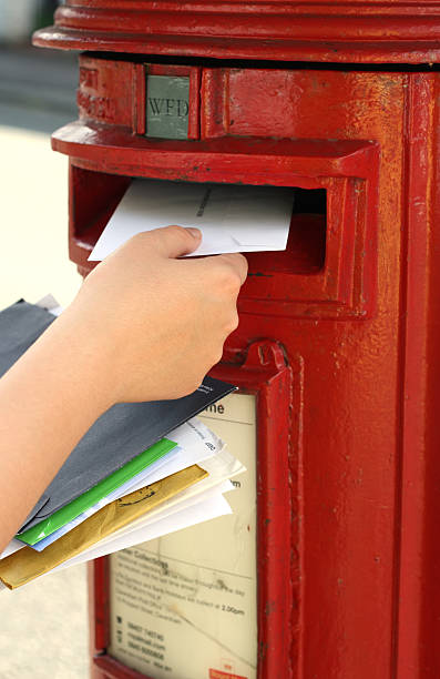istock girls hand posting letters to red british postbox 93149112