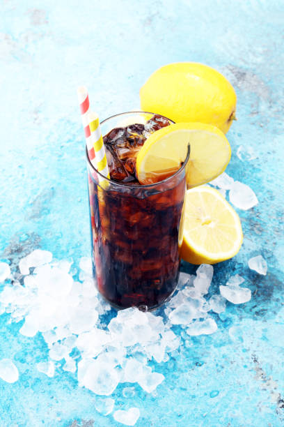 istock Softdrink with ice cubes, lemon and straw in glass. 931491924