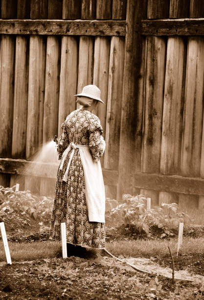 Lady in traditional dress watering the vegetable garden,Fort Langley Historical Village,Canada