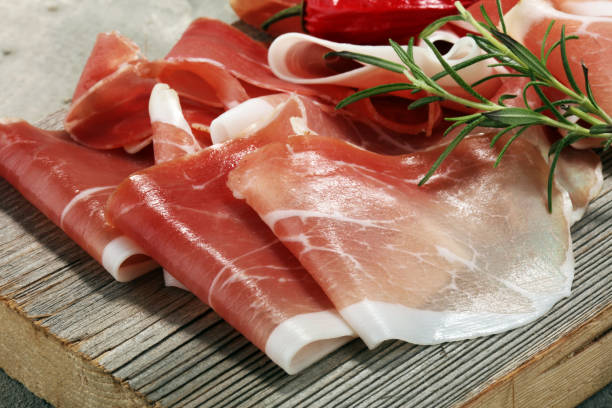 istock Italian prosciutto crudo or jamon with rosemary. Raw ham 931494764