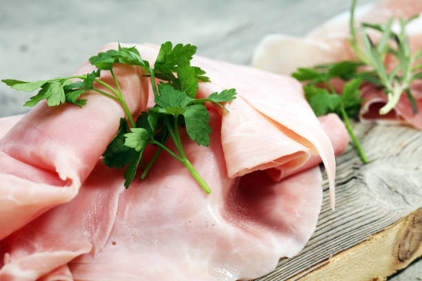 istock Sliced ham on wooden background. Fresh prosciutto. Pork ham sliced 931495288