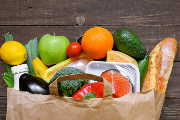 istock Different food in paper bag on rustic wooden background, 931505580