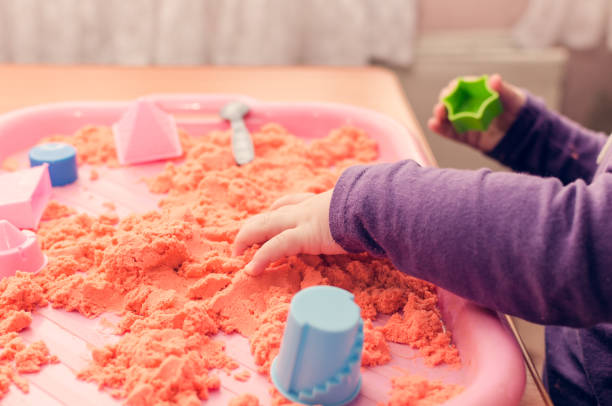 istock The hands of a child playing with kinetic sand 931508324