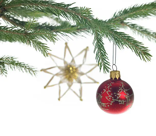 Studio photography of some christmas decoration with red christmas bauble and straw star in white back