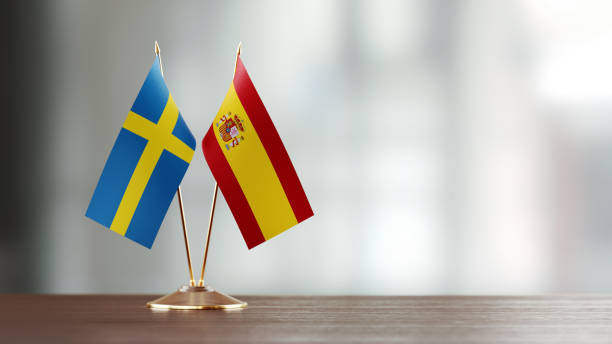 istock Swedish And Spanish Flag Pair On A Desk Over Defocused Background 931523866
